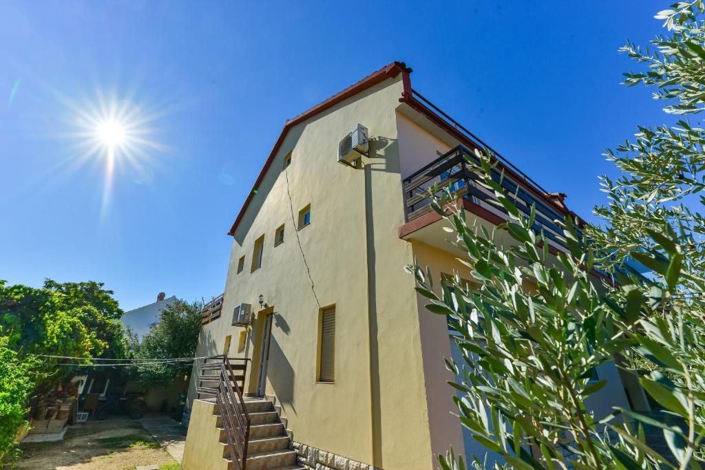 un edificio con el sol en el cielo en Apartments by the sea Bibinje, Zadar - 5786, en Bibinje