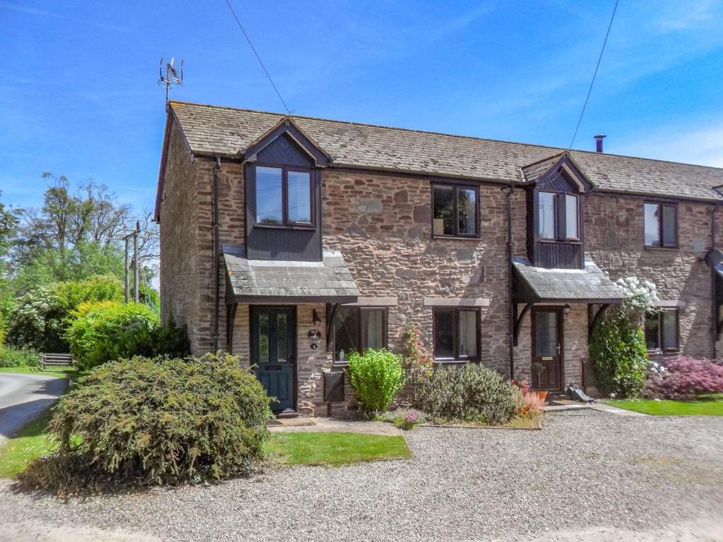 a large brick house with a driveway at Bear Cottage in Abbey Dore