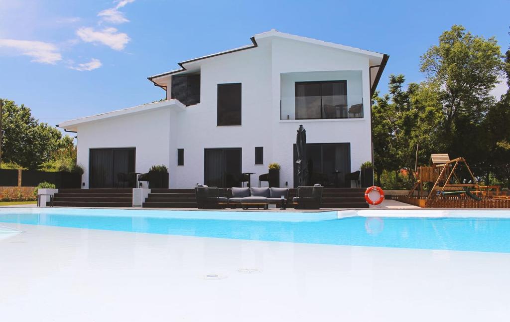 a villa with a swimming pool in front of a house at Granja da Cabrita in Coimbra