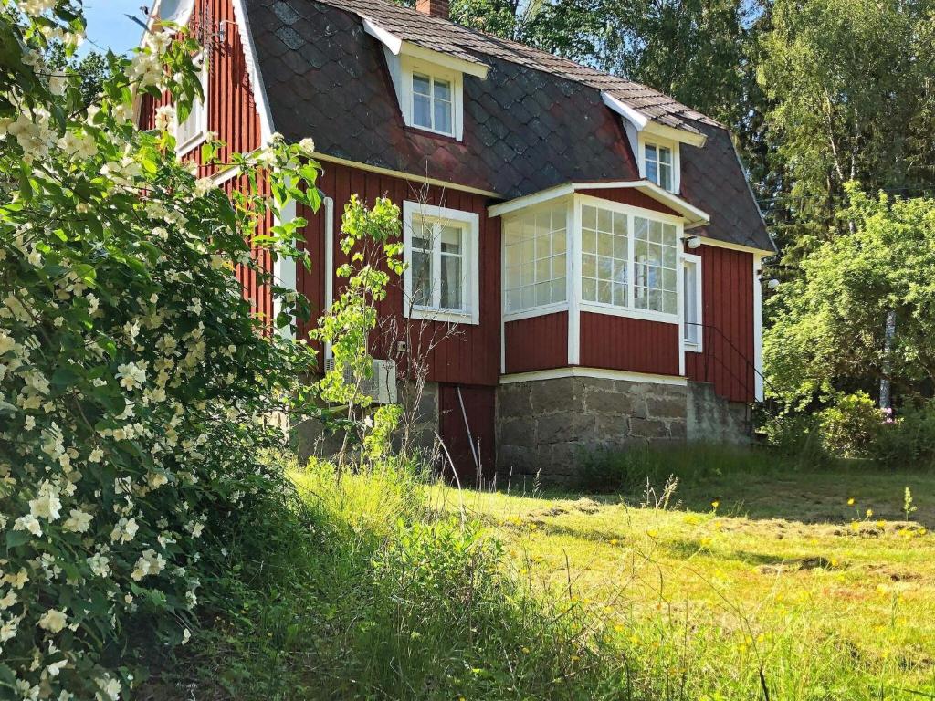 Casa roja con ventanas blancas y patio en Holiday home HALLABRO, en Hallabro
