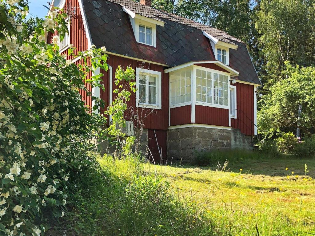 a red house with white windows and a yard at 6 person holiday home in Hallabro in Hallabro