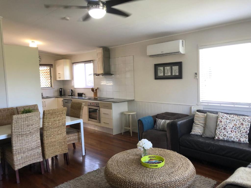 a living room with a couch a table and a kitchen at Redland BayBreeze in Redland Bay