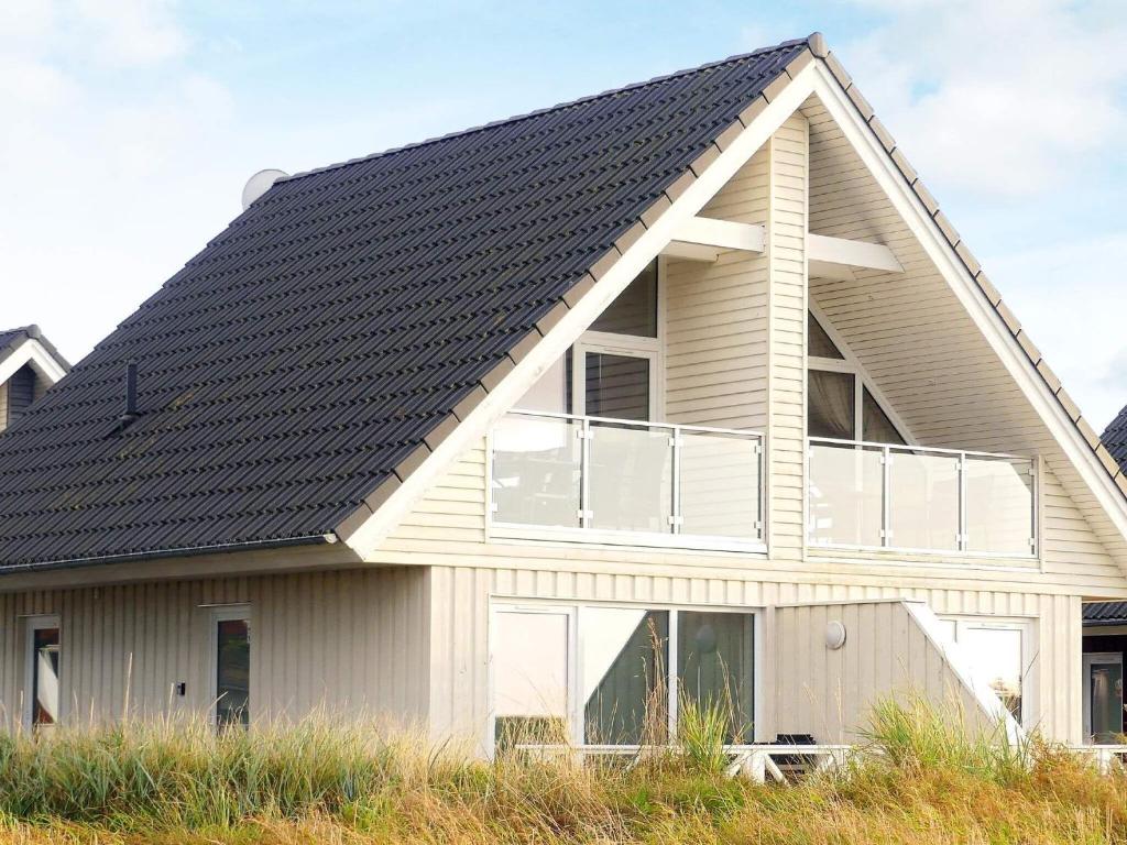 ein Haus mit schwarzem Dach in der Unterkunft 4 person holiday home in Wendtorf in Wendtorf
