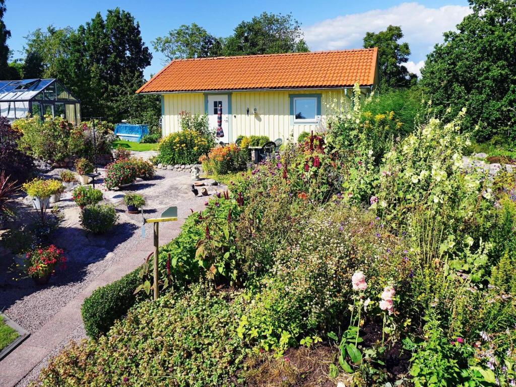 un jardin fleuri et une maison en arrière-plan dans l'établissement Holiday home BRASTAD XIII, à Brastad