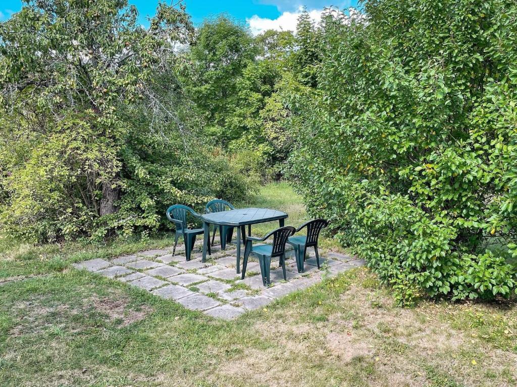 una mesa de picnic con 4 sillas en un camino de piedra en Holiday home GAMLEBY V, en Gamleby