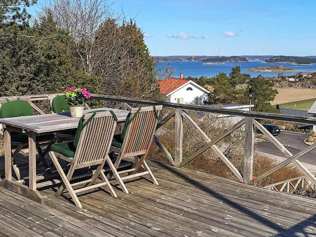 une table et des chaises en bois assises sur une terrasse dans l'établissement Holiday home STORAHÖGA II, à Stora Höga