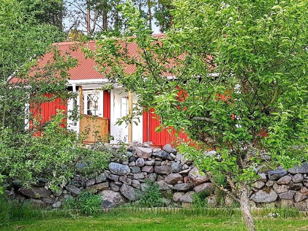 uma casa vermelha e branca com uma parede de pedra em 6 person holiday home in BJ RKVIK em Björkvik