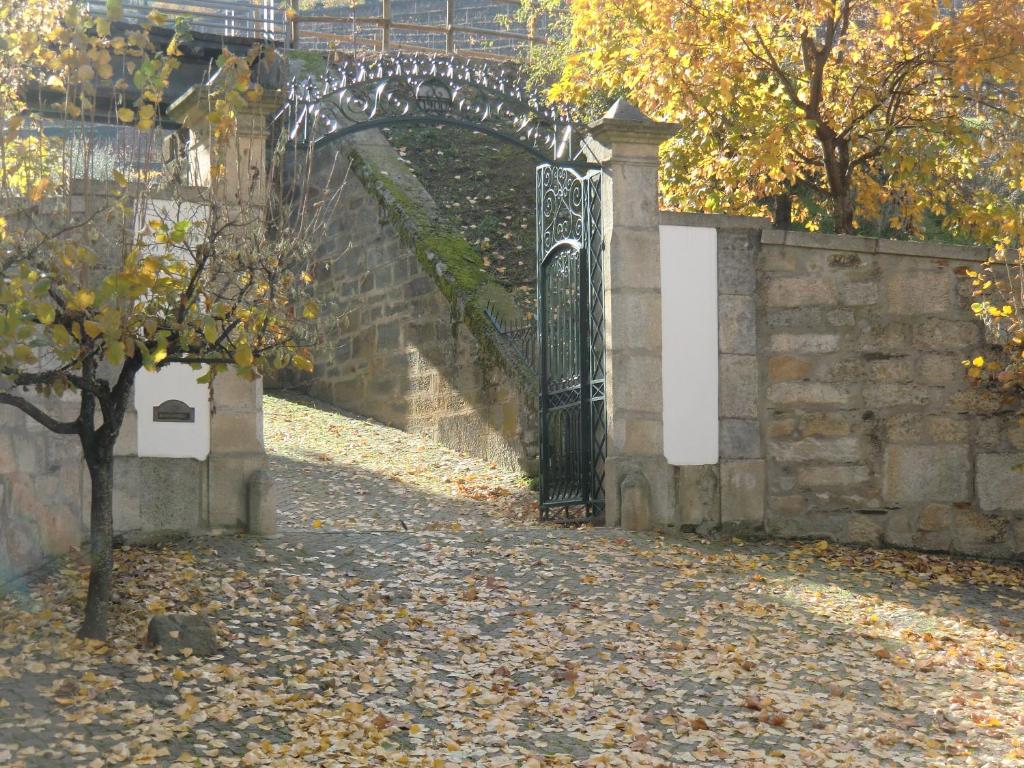 an entrance to a stone wall with a black gate at Quinta das Aveleiras in Torre de Moncorvo