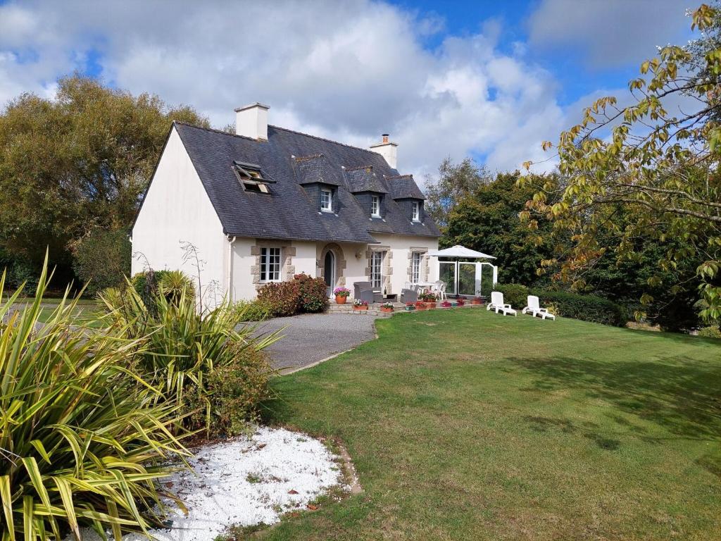 ein weißes Haus mit Garten und Rasen in der Unterkunft Breton cottage in a quiet location with fireplace, Plouenan in Plouénan