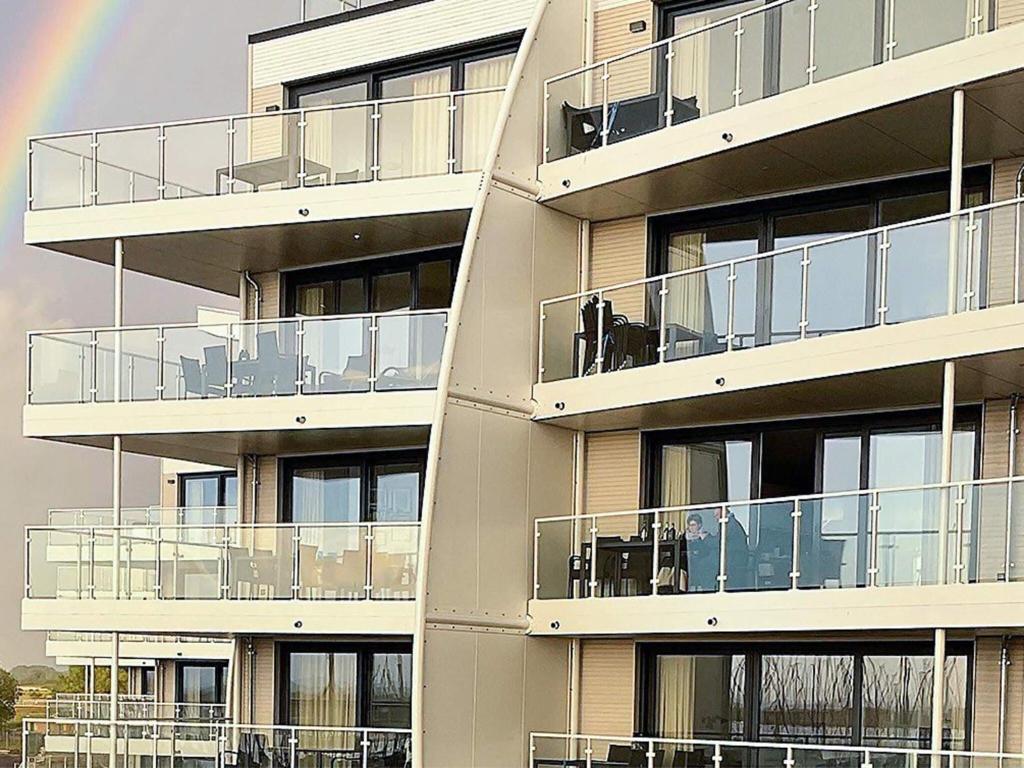 a building with a rainbow in the background at Exklusive Meerblickwohnung in 1 Reihe in Wendtorf