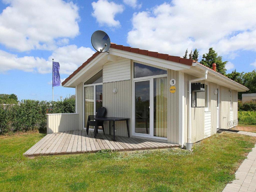 ein kleiner Schuppen mit einem Tisch auf einer Holzterrasse in der Unterkunft Two-Bedroom Holiday home in Grömitz 7 in Grömitz