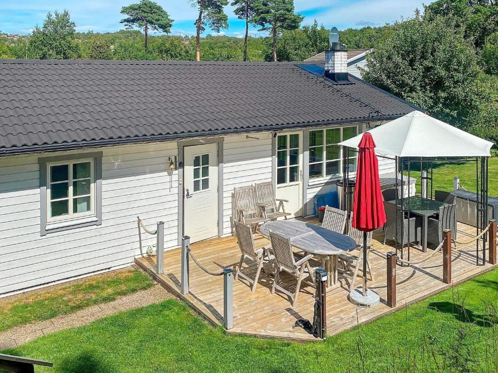 a deck with a table and an umbrella at Holiday home KUNGSHAMN XI in Kungshamn
