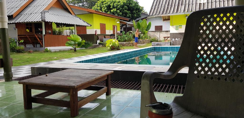 a chair sitting next to a swimming pool with a bench at Peace of Love Pai in Pai