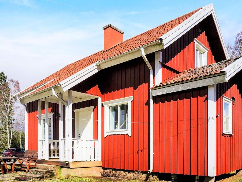 a red and black house with a white door at 8 person holiday home in LJUNG in Ljung