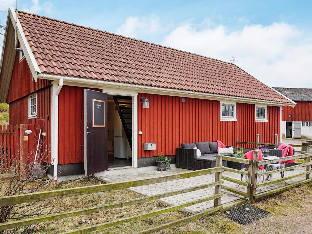 a red house with a wooden fence in front of it at 5 person holiday home in LINDOME SVERIGE 