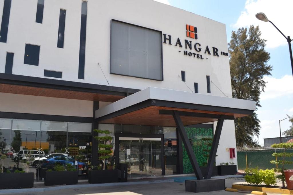 un grande edificio bianco con un cartello sopra di Hangar Inn Guadalajara Aeropuerto a Guadalajara