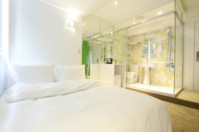 a bedroom with a large white bed and a shower at Forever Inn in Taipei
