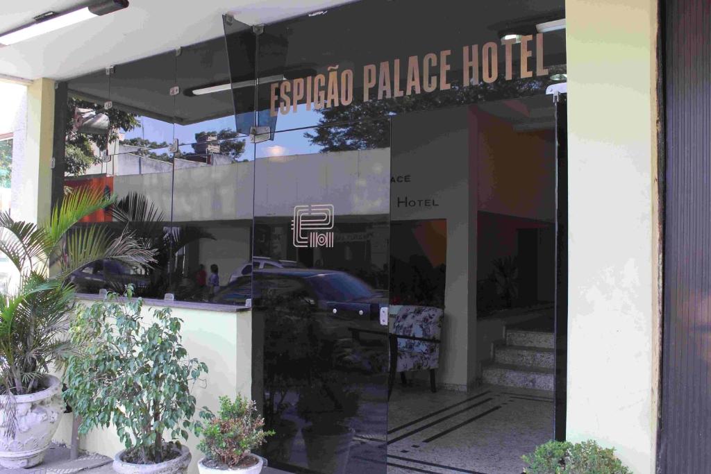 un frente de tienda con un reflejo de un coche en la ventana en Espigão Palace Hotel, en Resende