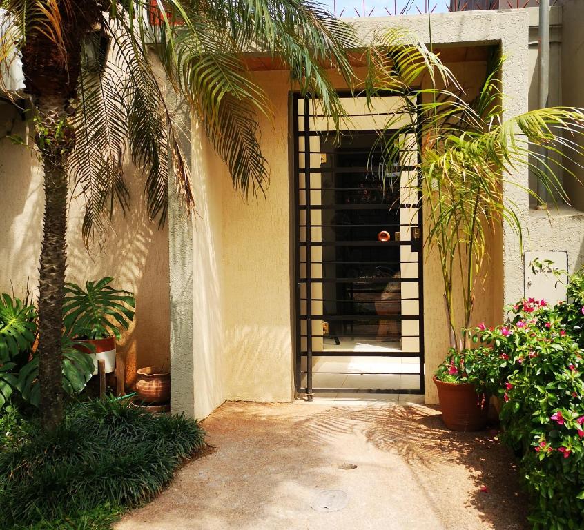 a door to a house with a palm tree and plants at Violeta Roga in Asunción