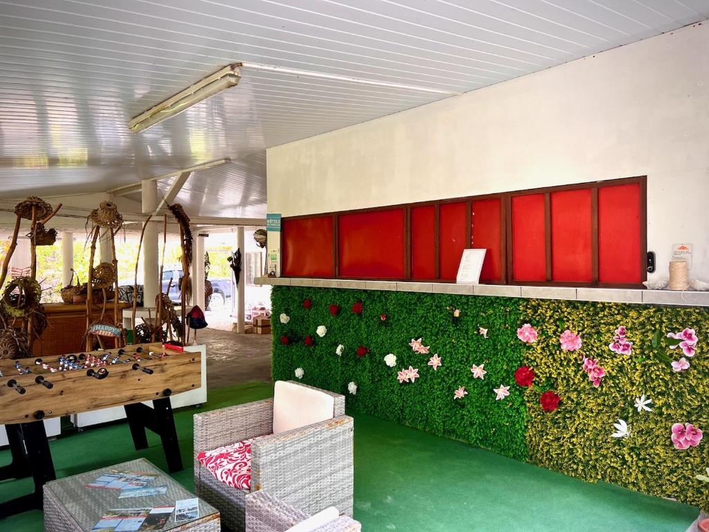 uma cozinha com uma parede verde com flores em Va'a i te Moana em Avatoru