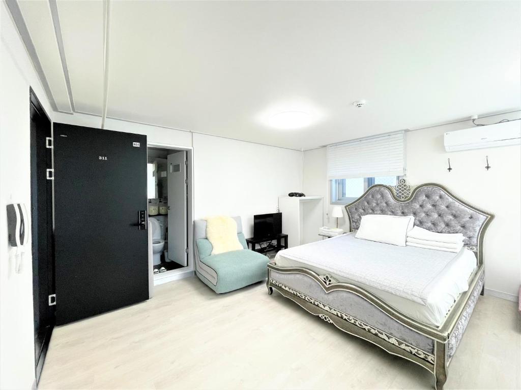 a bedroom with a bed and a chair in it at W Premium Guesthouse Incheon airport in Incheon