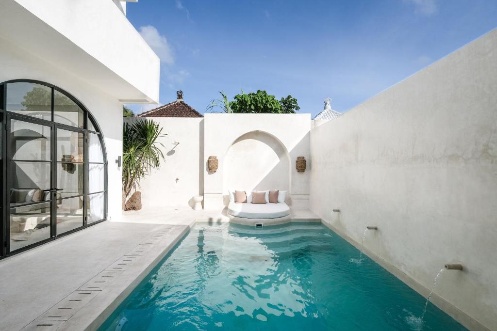 a swimming pool in a house with a white wall at Mahi Mahi Villa & Suites in Uluwatu