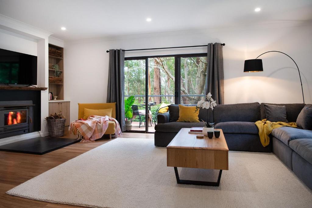 a living room with a couch and a fireplace at Selo Retreat- escape to this forest retreat in Glenlyon