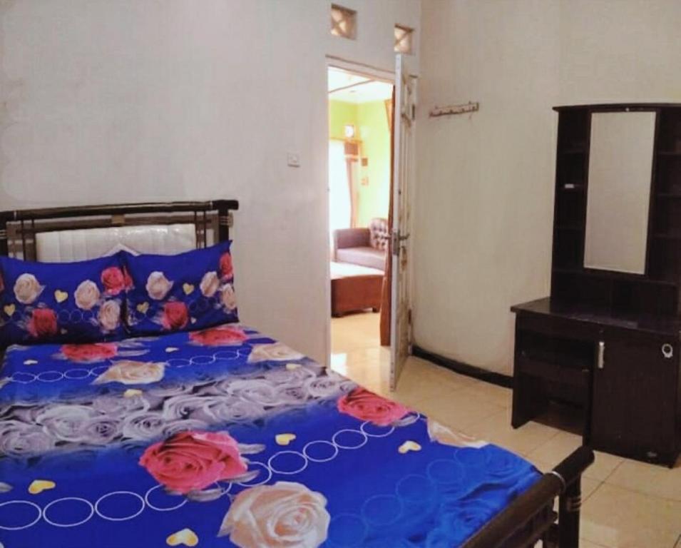 a bedroom with a bed and a dresser and a mirror at Guest House Dissa in Purwokerto