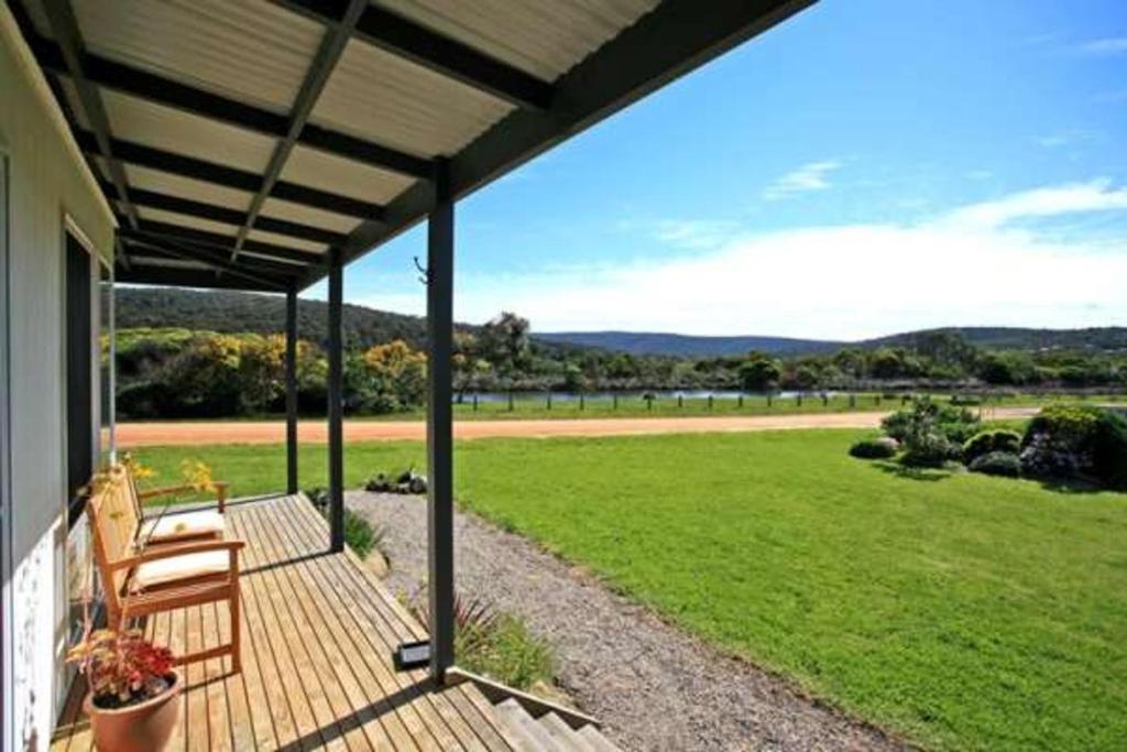 a porch with two chairs and a view of a field at A River Bed in Aireys Inlet