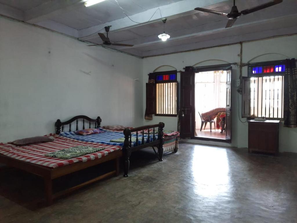 1 dormitorio con 2 camas y puerta abierta en Moray homestay, en Malvan