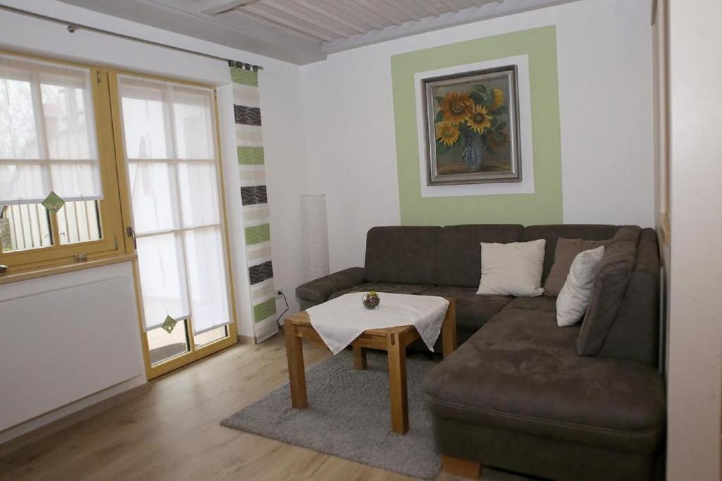ein Wohnzimmer mit einem Sofa und einem Tisch in der Unterkunft Ferienwohnungen Herzog in Haundorf