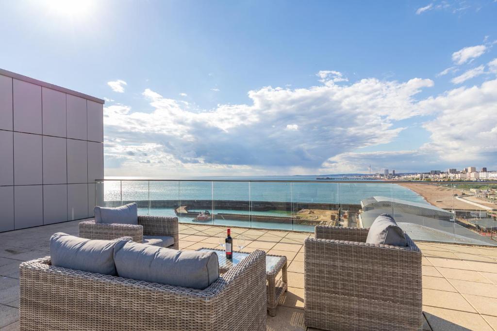 a patio with chairs and a view of the ocean at Unique Sea View Penthouse with Hot Tub in Brighton & Hove
