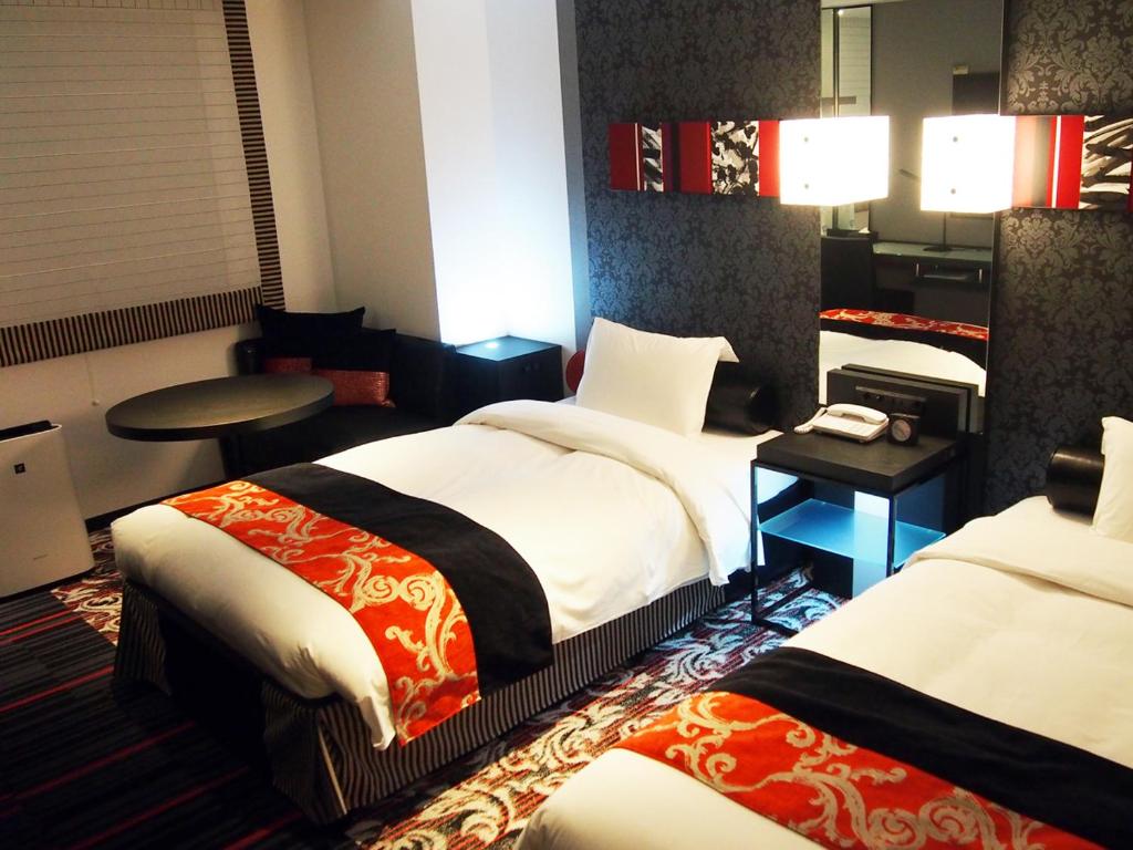 a hotel room with two beds and a table at New Otani Inn Tokyo in Tokyo