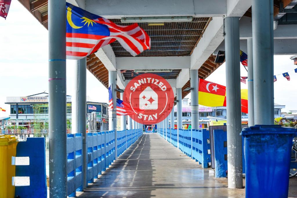 a walkway with flags on the side of a pier at OYO 90627 Pulau Ketam Inn in Klang