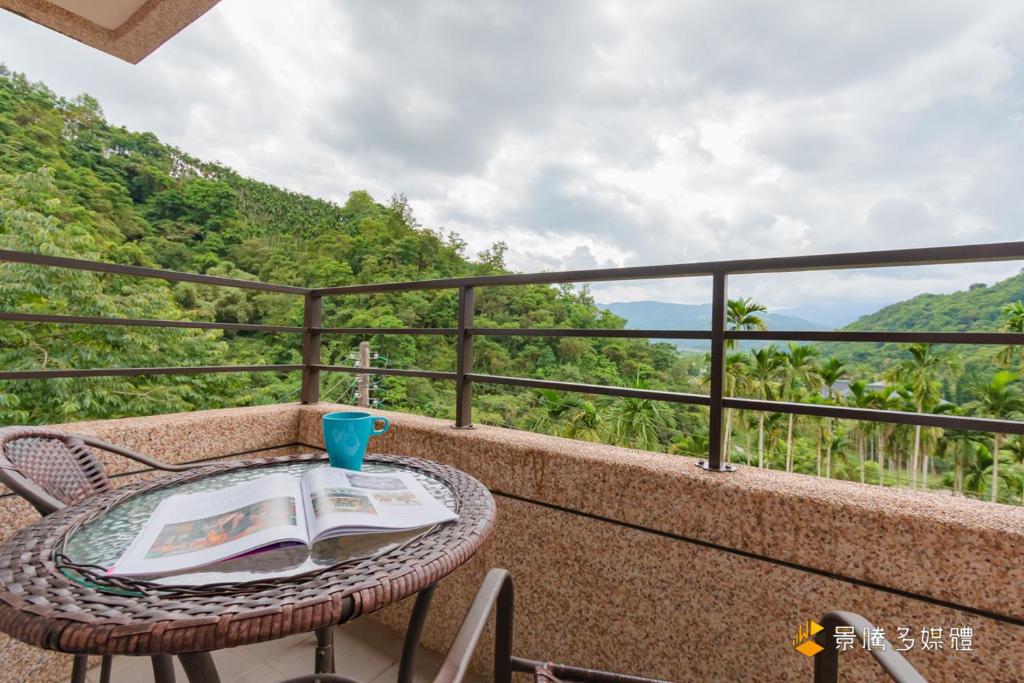 a table and chairs on a balcony with a view at Atayal Villa in Datong