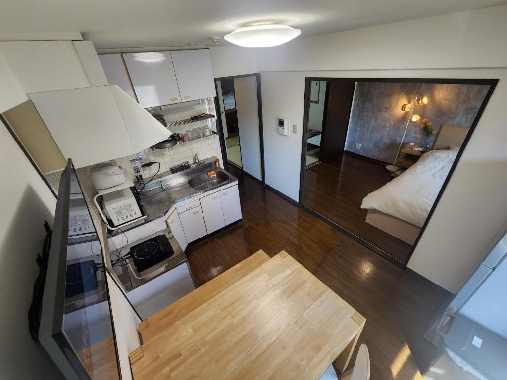 una pequeña cocina con una mesa y una cama en una habitación en MORI Apartment 道頓堀(Dotonbori) 2DK, en Osaka