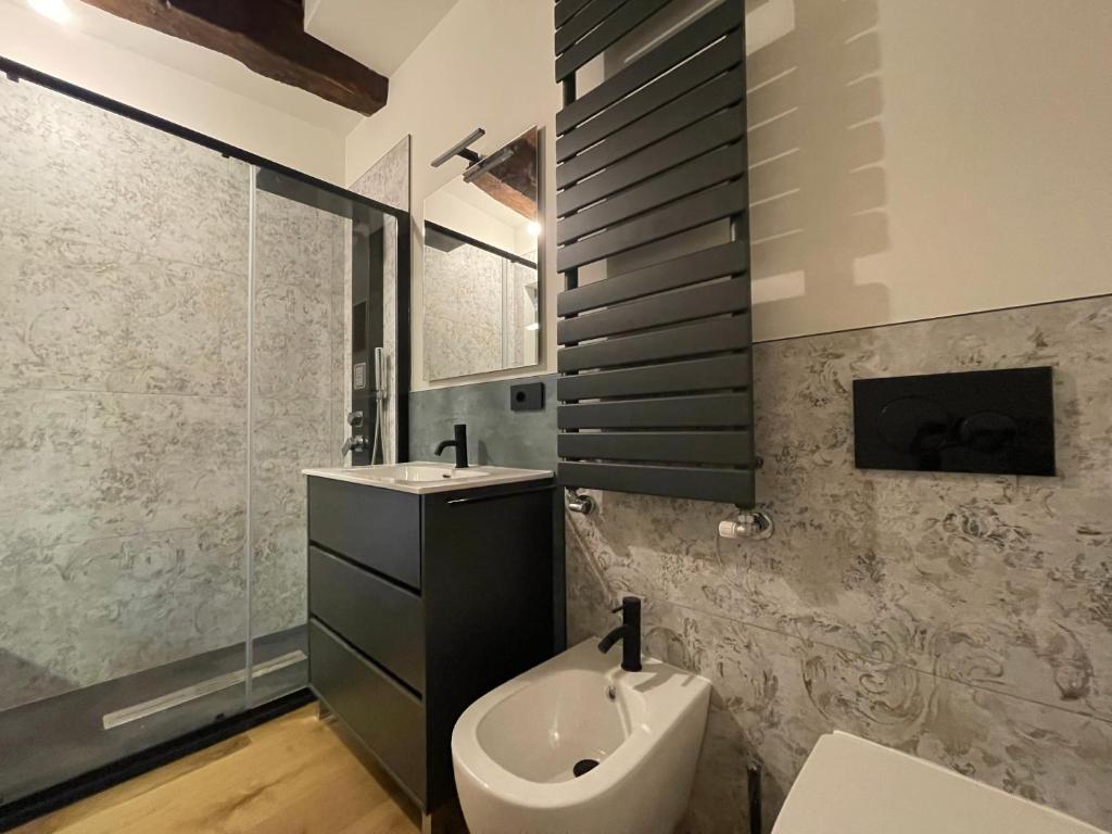 a bathroom with a sink and a toilet in it at La dimora della Giudecca - 13 in Cuneo