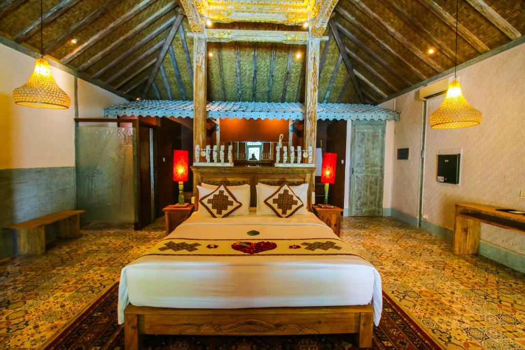 a bedroom with a large bed in a room at Kupu Kupu Jimbaran Beach Hotel & Spa by L’Occitane in Jimbaran