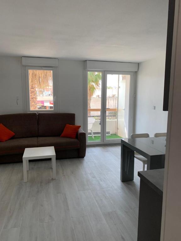 un salon avec un canapé et une table dans l'établissement Appartement 4 personnes vue mer, coeur de ville, au Grau-du-Roi