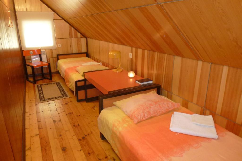 Habitación con 2 camas y mesa con escritorio. en Kihelkonna Pastorate Guesthouse en Kihelkonna