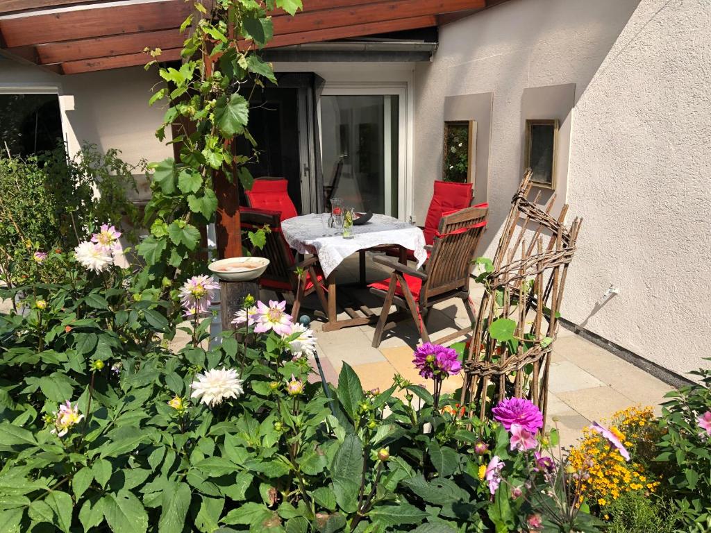 a patio with a table and chairs and flowers at Gartenblick in Leichlingen