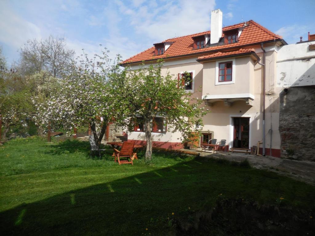 a white house with an apple tree in the yard at Domek kata Matěje in Český Krumlov