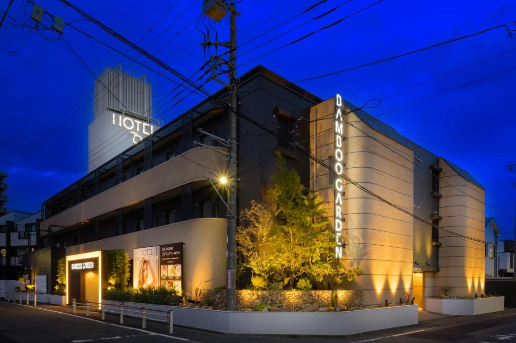 a hotel building with a sign on it at night at BAMBOO GARDEN 相模原 in Sagamihara