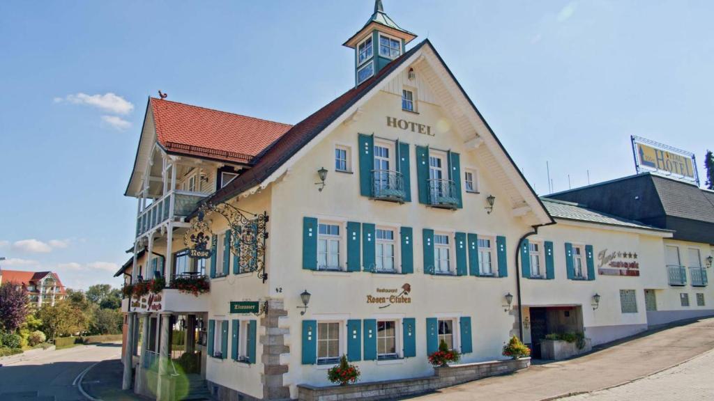 菲希特瑙的住宿－Meiser Rosenstuben Hotel，一条白色的大建筑,在街上有蓝色百叶窗