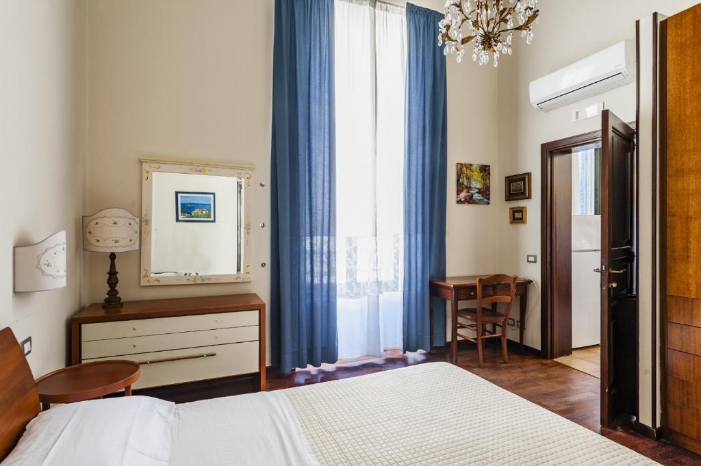 sypialnia z łóżkiem, biurkiem i lustrem w obiekcie Grimaldi 8 Apartment by Wonderful Italy w Katanii