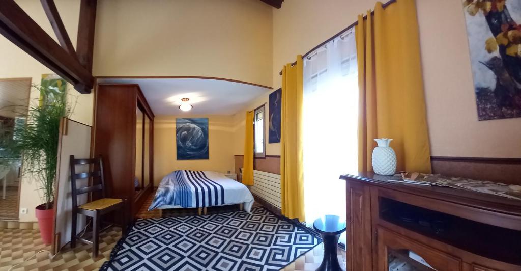 Habitación con dormitorio con cama y ventana en Logement unique dans le Lot, en Leyme