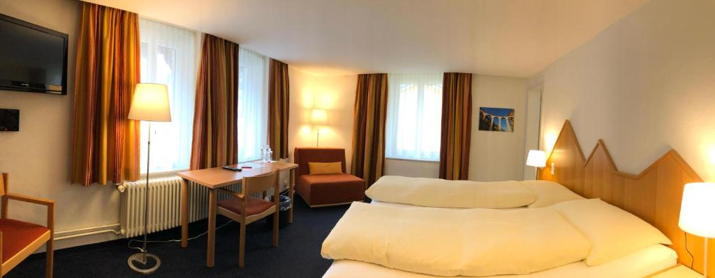 Postel nebo postele na pokoji v ubytování Hotel Weisses Kreuz Bergün