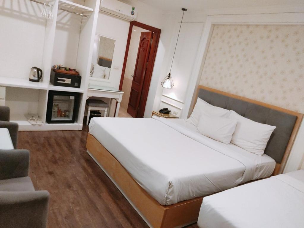 a bedroom with two beds and a fireplace at Khách Sạn A83Hotel in Hanoi