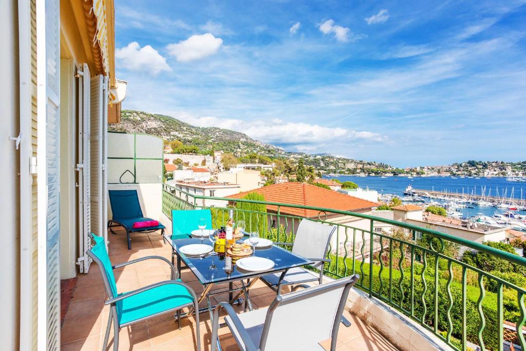 d'un balcon avec une table et des chaises et une vue sur l'eau. dans l'établissement LA MALMAISON II AP4315 By Riviera Holiday Homes, à Villefranche-sur-Mer