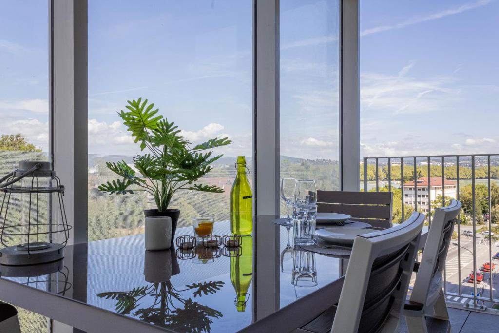 a dining room with a table with a bottle of wine at LE TRESUM - Garage, Balcon & Vue lac! in Annecy